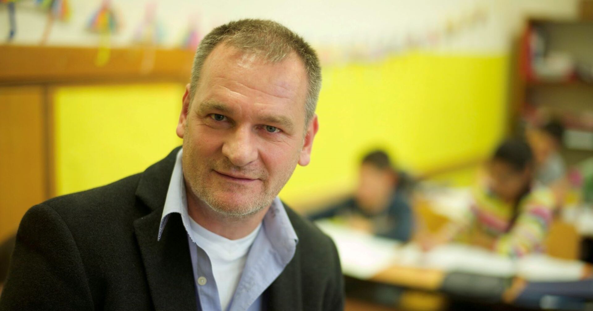 Direktor Christian klar steht im Klassenzimmer seiner Schule