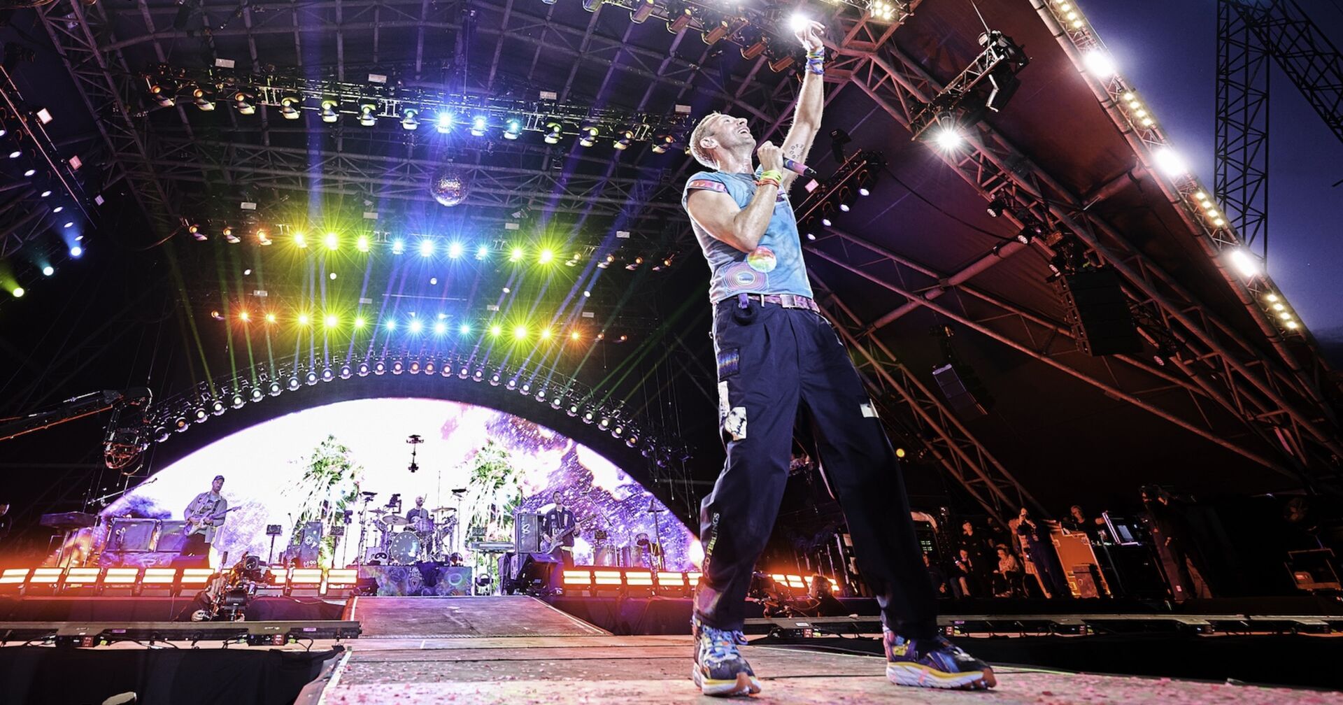 Chris Martin, der Sänger von Coldplay, steht auf der Bühne und singt.