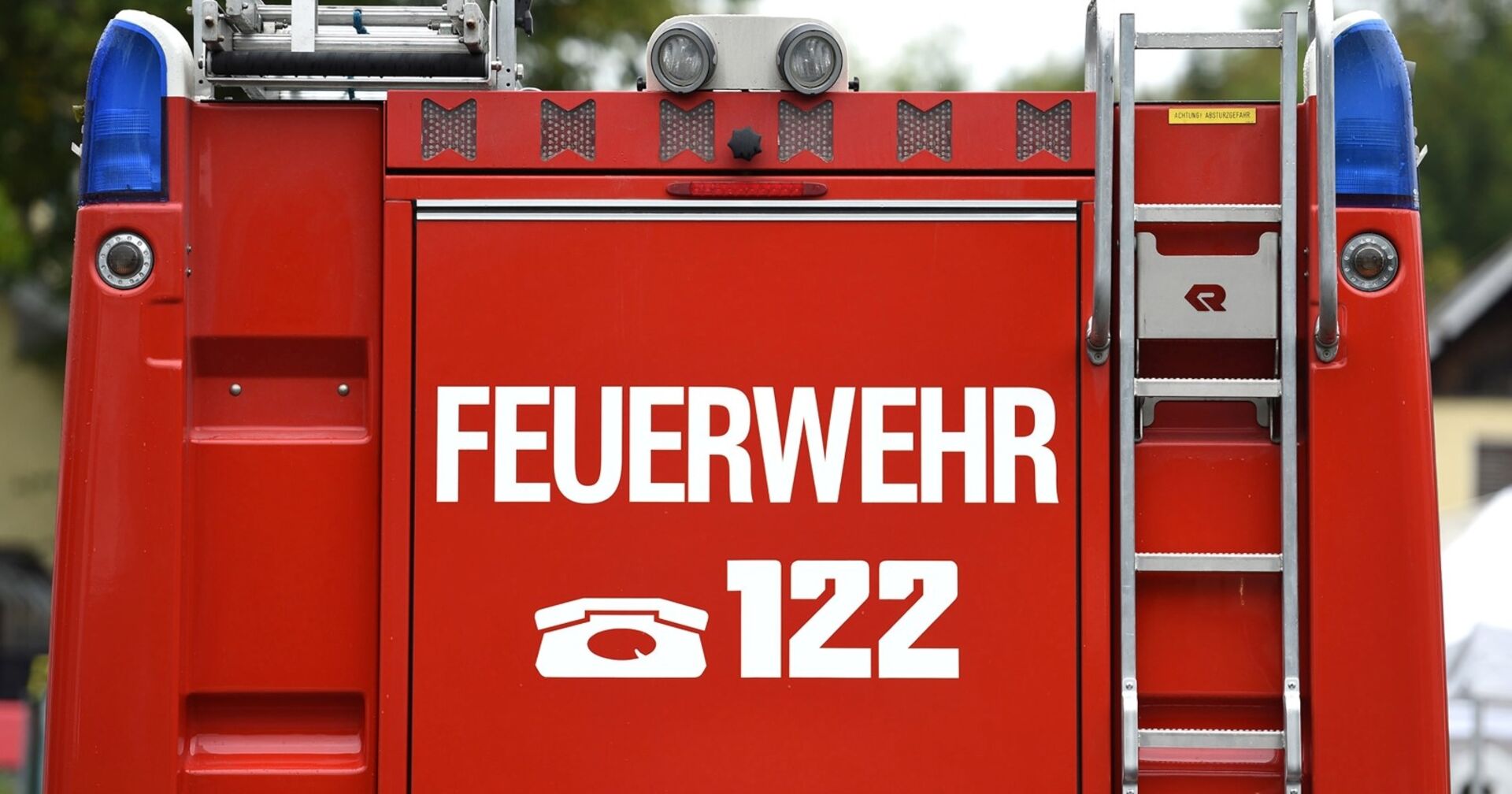 Rückseite eines roten Feuerwehrautos mit Notrufnummer