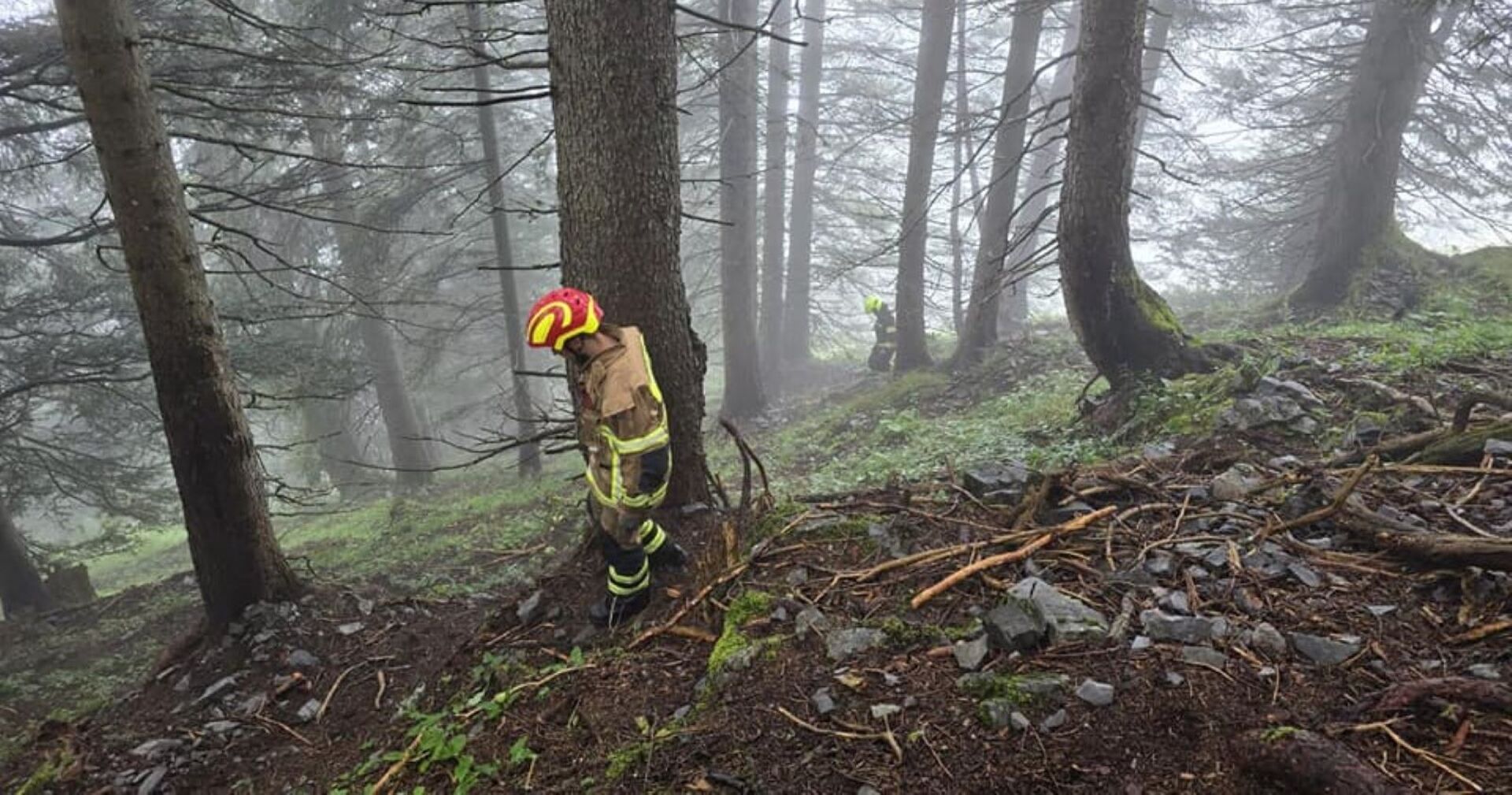 Feuerwehrmänner suchen im steilen Gelände der Brüggele Alpen nach der Fluggastzelle der in Vorarlberg abgestürzten Kleinmaschine
