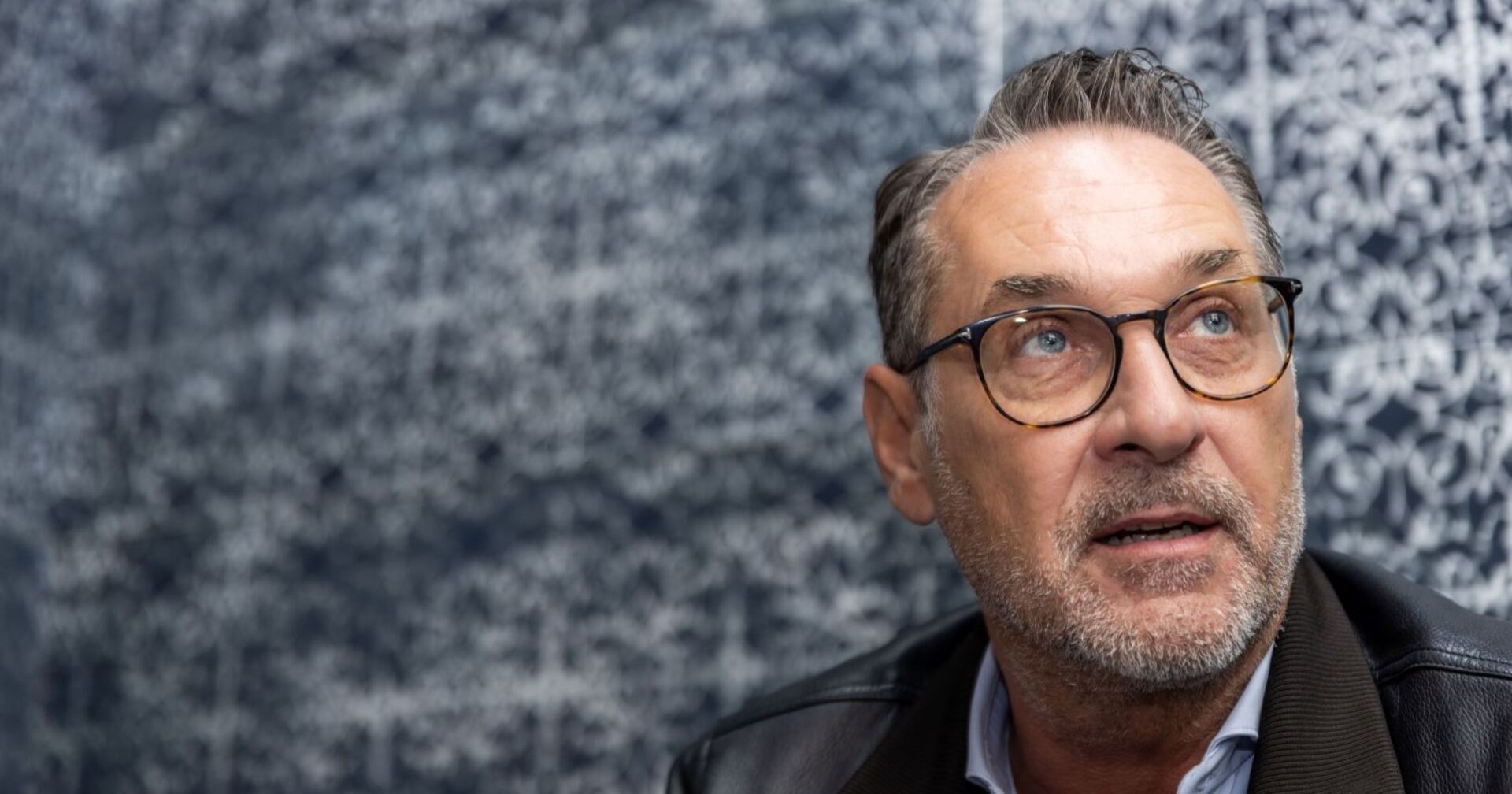 Strache sitzt und blickt nachdenklich in die Ferne