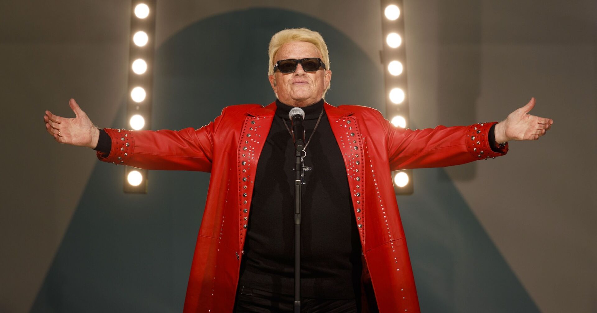 Heino in einem roten Mantel auf der Bühne.