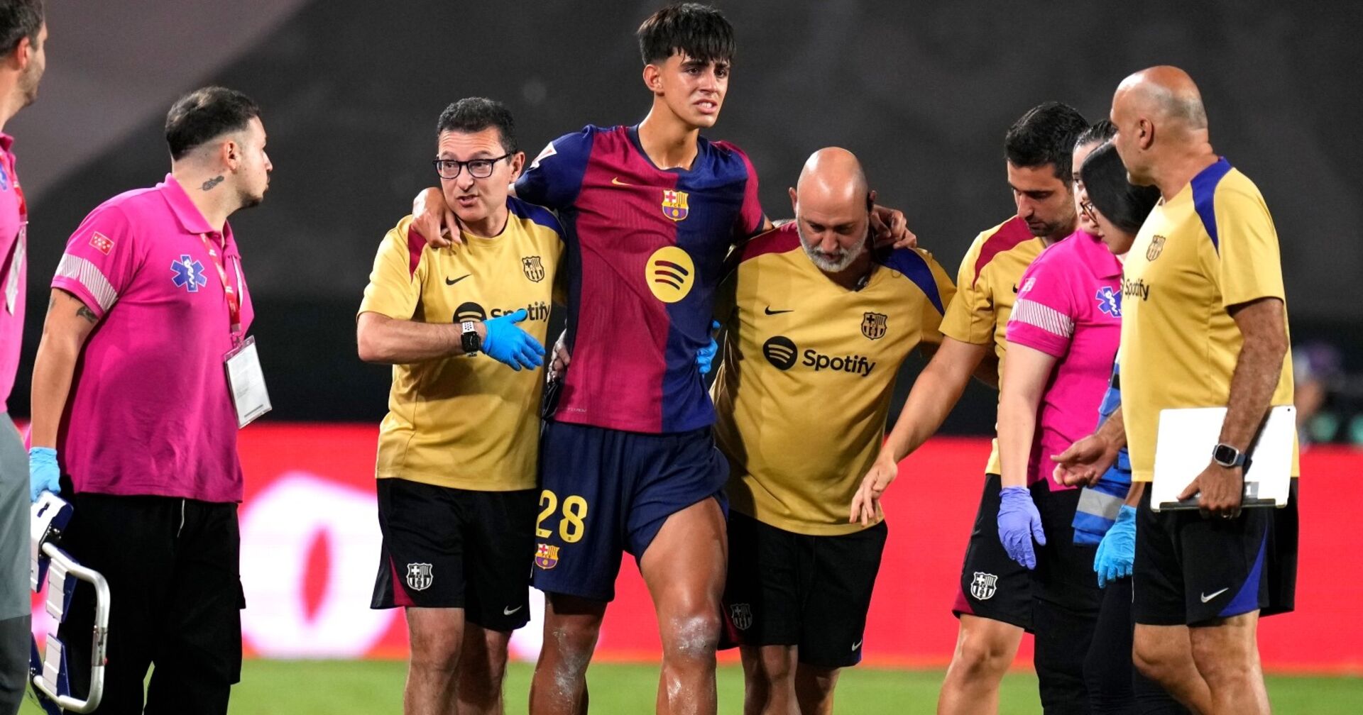 Der Spieler Marc Bernal verlässt, gestützt von zwei Betreuern das Feld