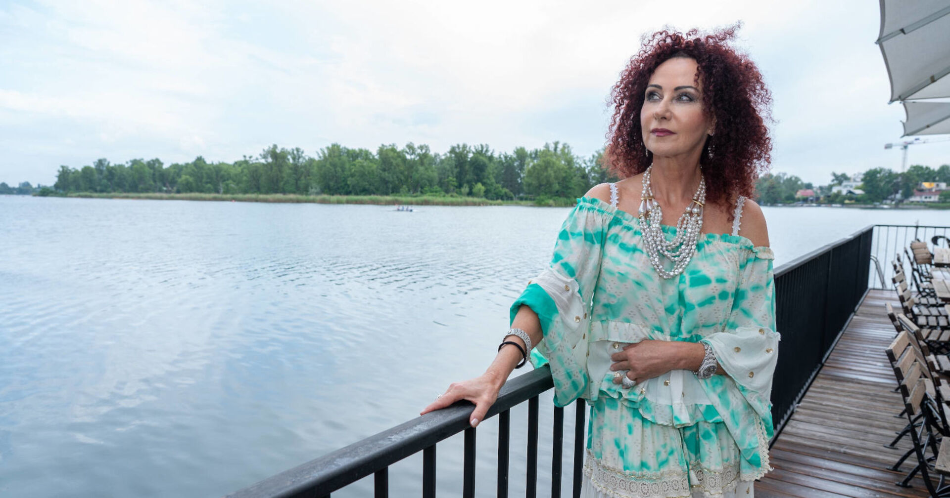 Frau starrt an einem See in die Ferne