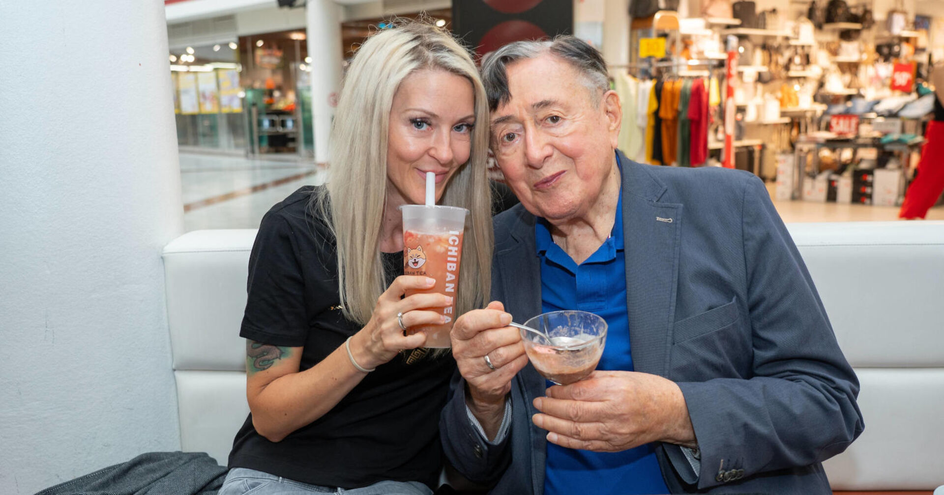 Eine Frau und ein Mann sitzen nebeneinander und trinken Kaffee