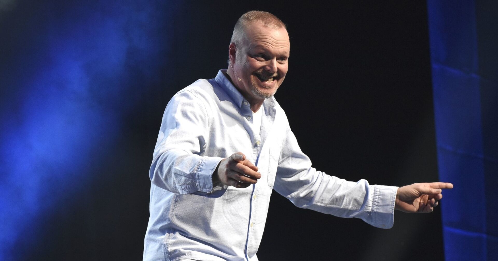 Stefan Raab in hellblauem Hemd mit beiden Armen ausgestreckt
