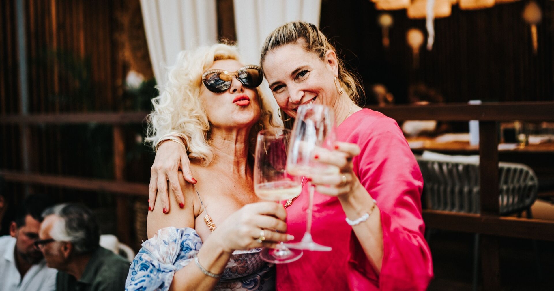 Zwei blonde Frauen stoßen miteinander an