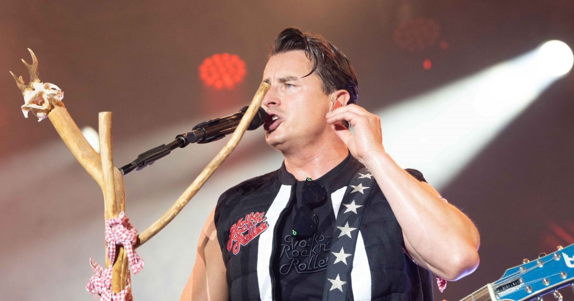 Andreas Gabalier singt in ein Mikrophon auf der Bühne.