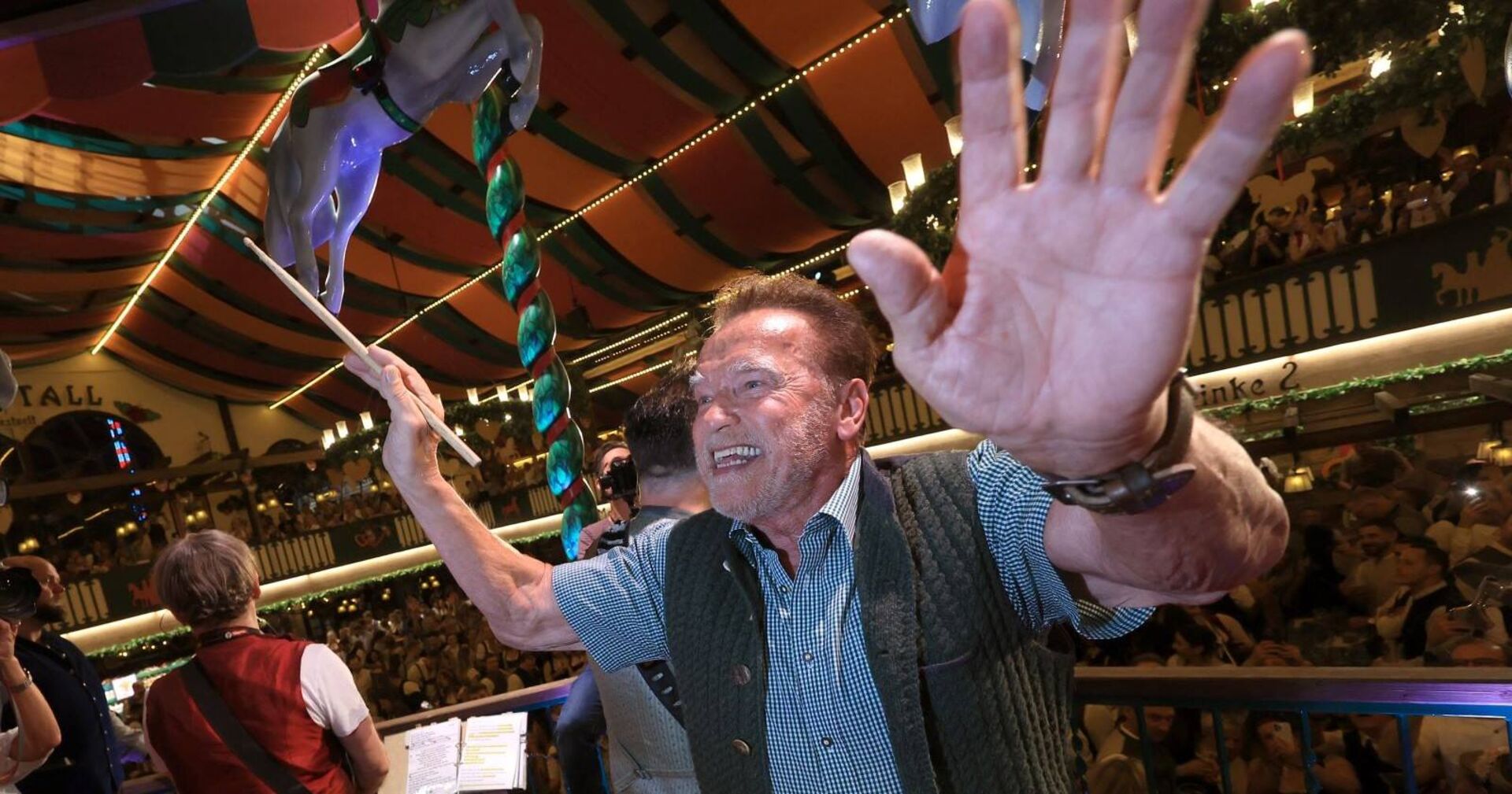 Arnold Schwarzenegger dirigiert die Band im Festzelt auf dem Oktoberfest.