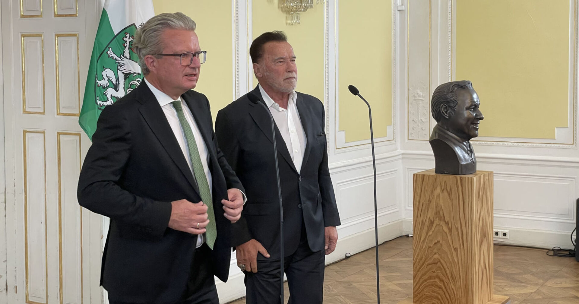 Zwei Männer in Anzügen stehen nebeneinander