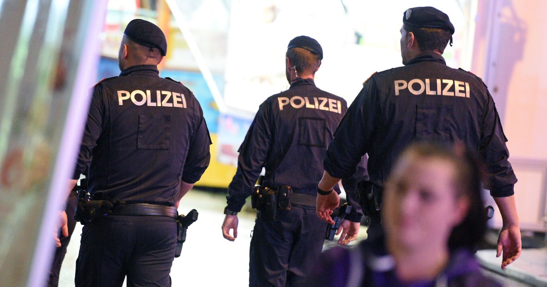 Drei Polizisten von hinten im Einsatz.