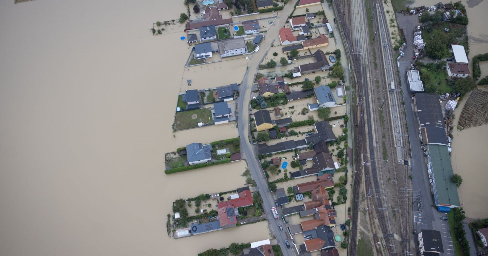 Luftaufnahme: eine Ortschaft in Niederösterreich steht vollständig unter Wasser, Häuser und einzelne Straßen ragen noch aus den schlammigen Fluten