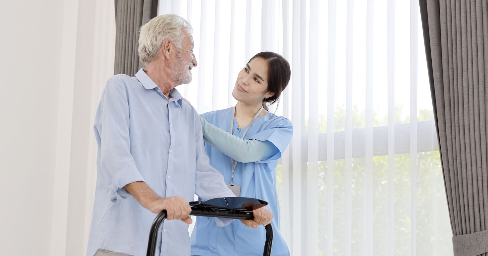 Pflegerin kümmert sich um älteren Herren, der auf einem Laufband steht