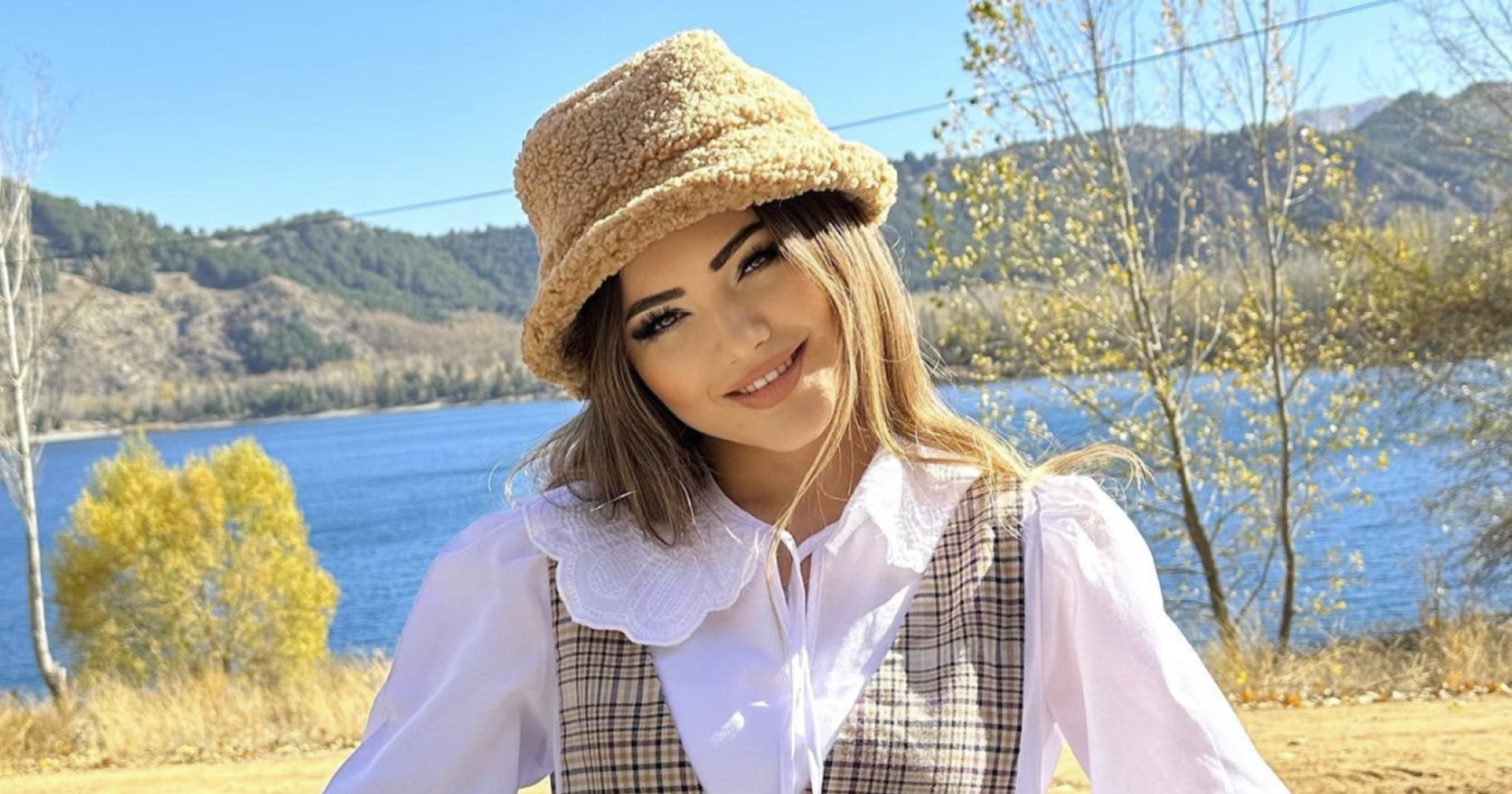 Influencerin Kübra Aykut mit einem Hut lächelt in die Kamera.