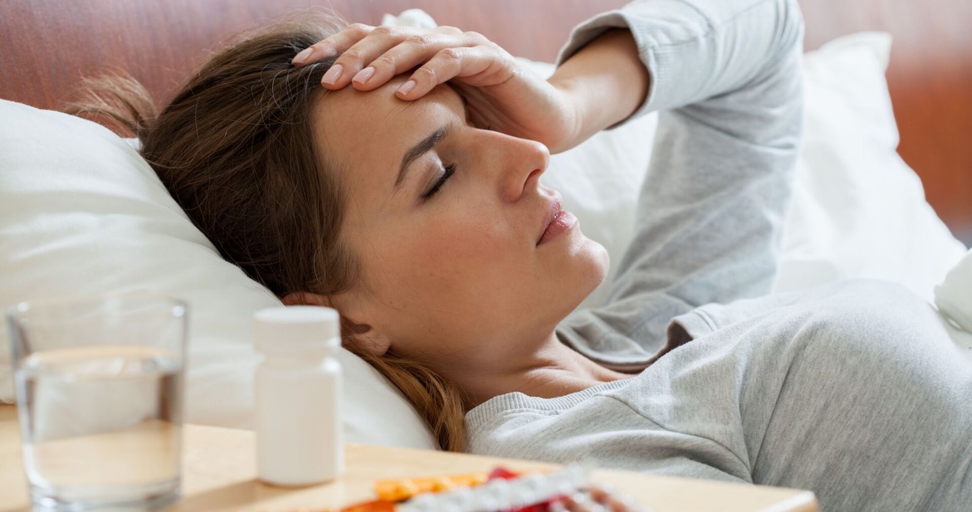 Eine Frau liegt krank im Bett.