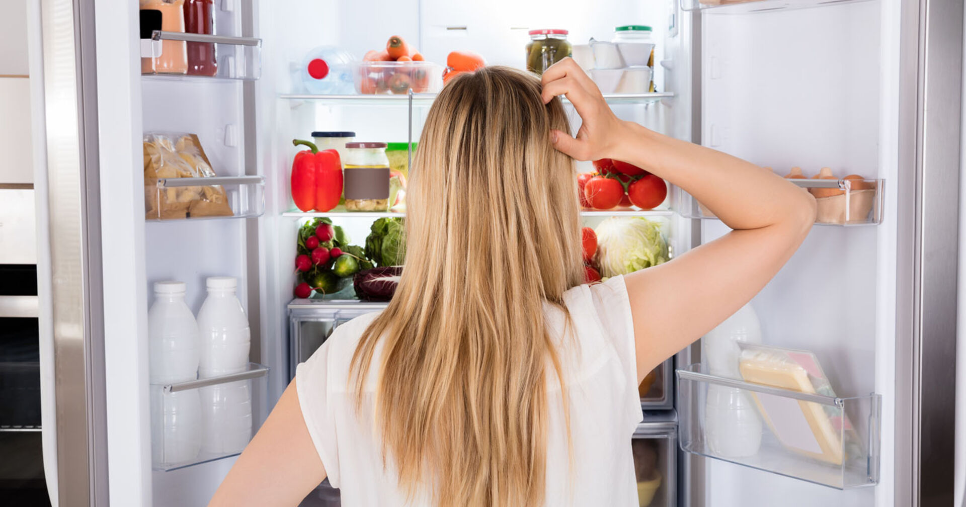 Frau steht ratlos vor dem Kühlschrank | Credit: iStock.com/AndreyPopov