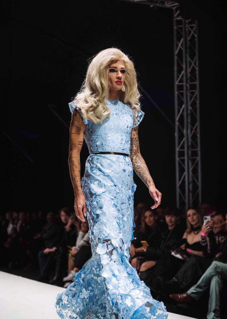 Eine Frau in einem eisblauen Kleid am Laufsteg