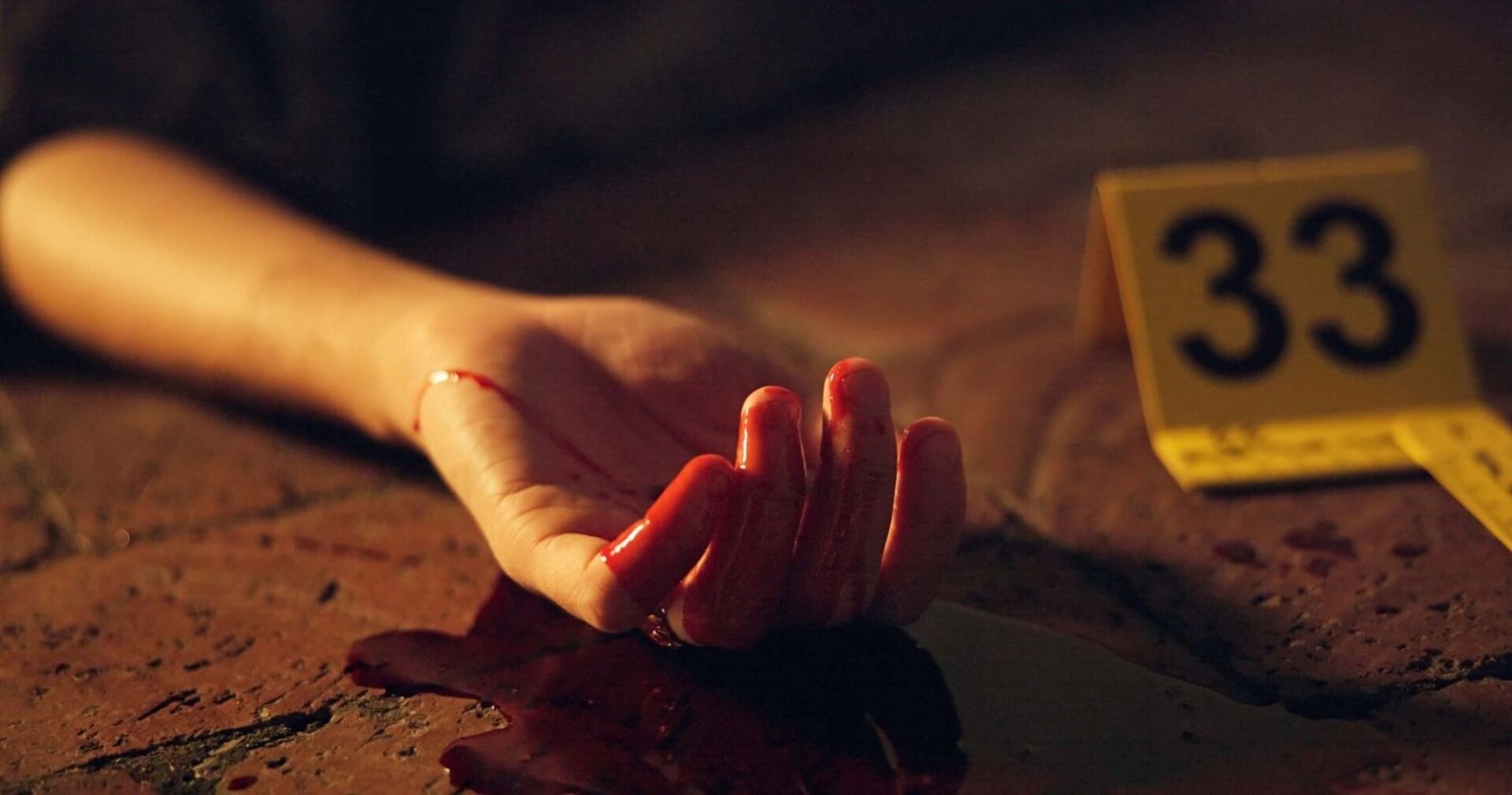 Eine Frauenhand an einem Mordtatort.