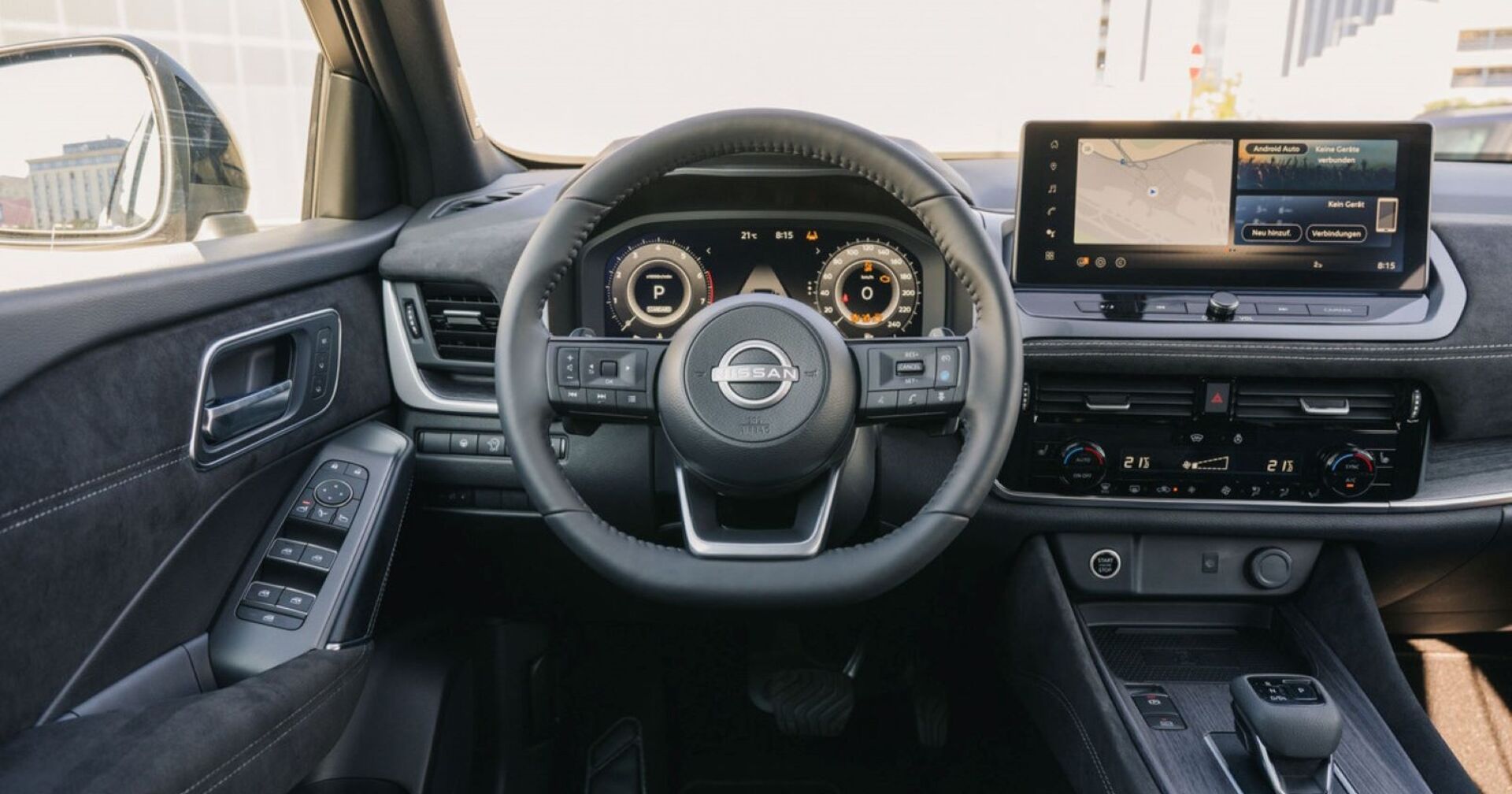 Das Innere des Nissan Qashqai: Die Sitze, das Lenkrad und die Instrumente sind schwarz. Das kleine Display des Navigationssystems ist in der Mitte des Autos angebracht.