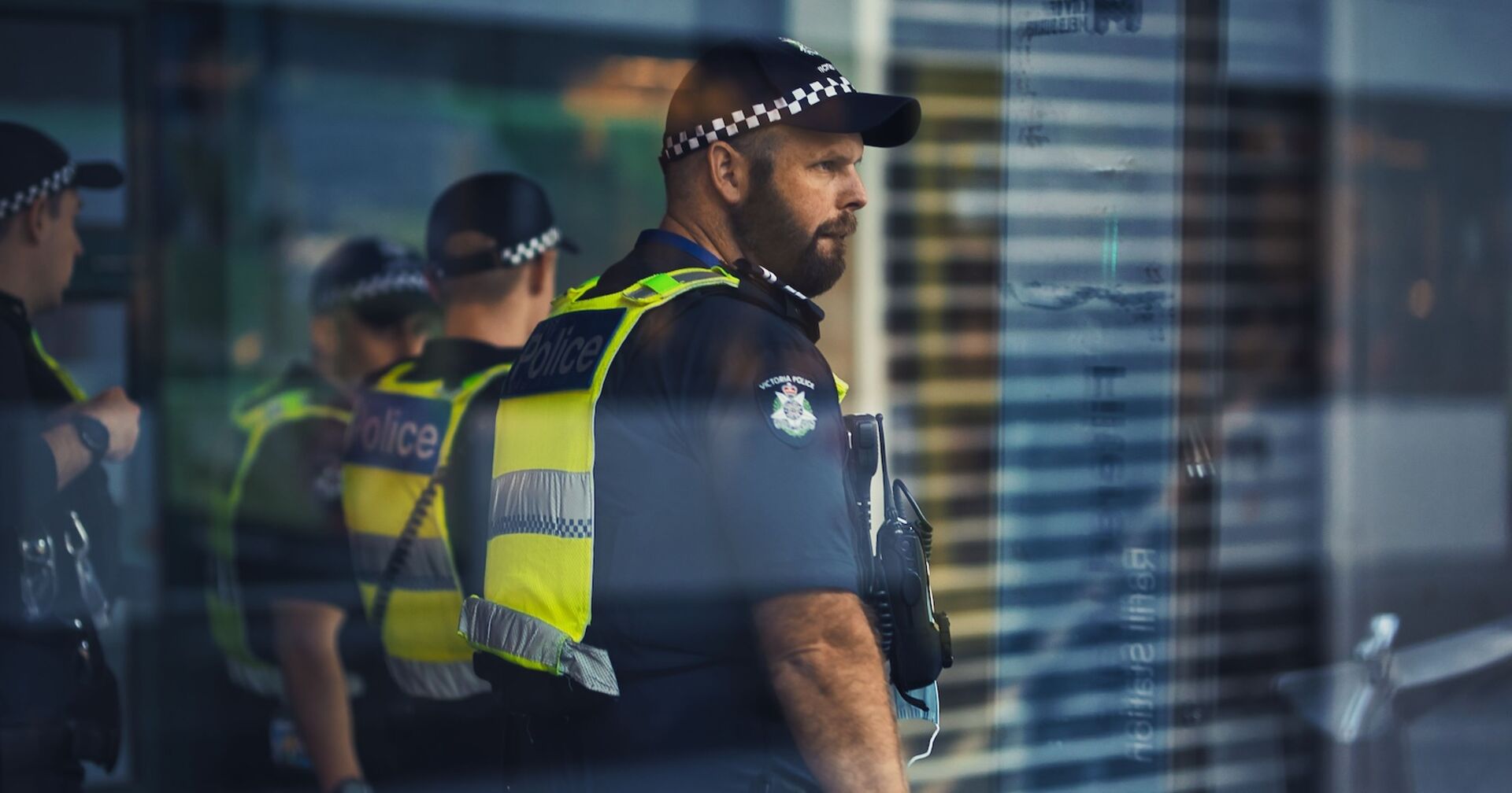 Australische Polizeibeamten hinter einer Glasfront.