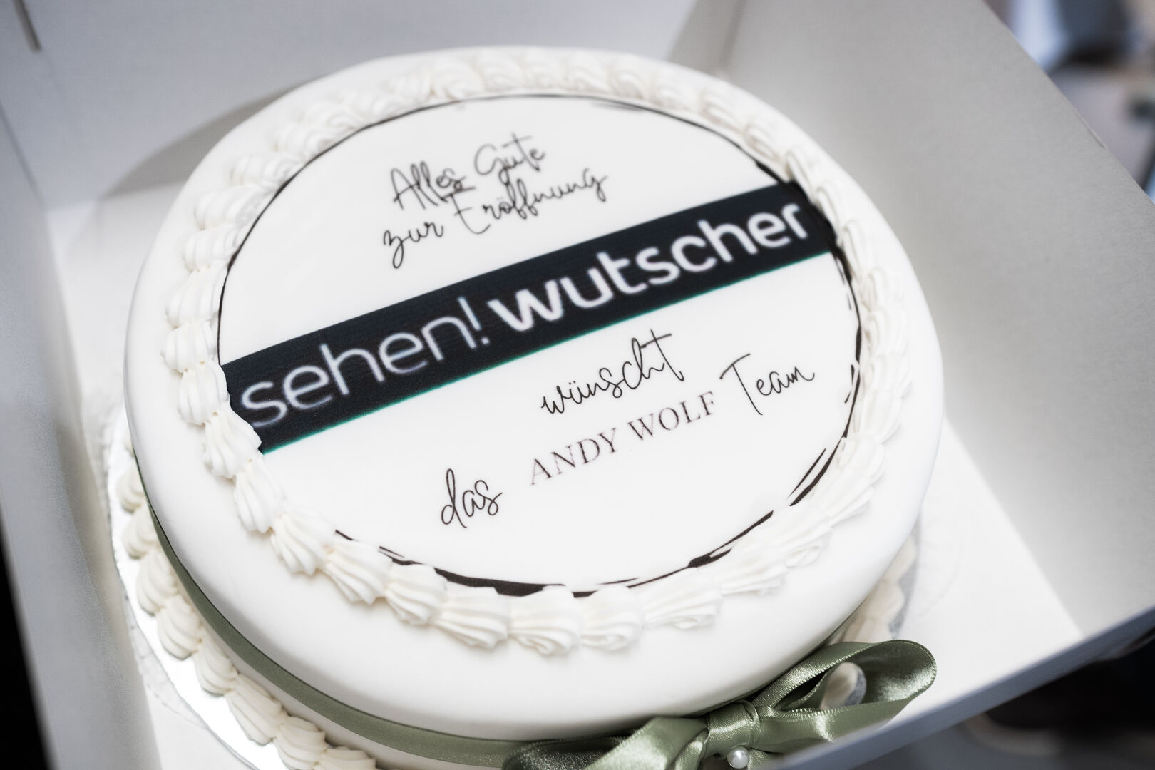 Eine weiße Torte mit schwarzer Schrift