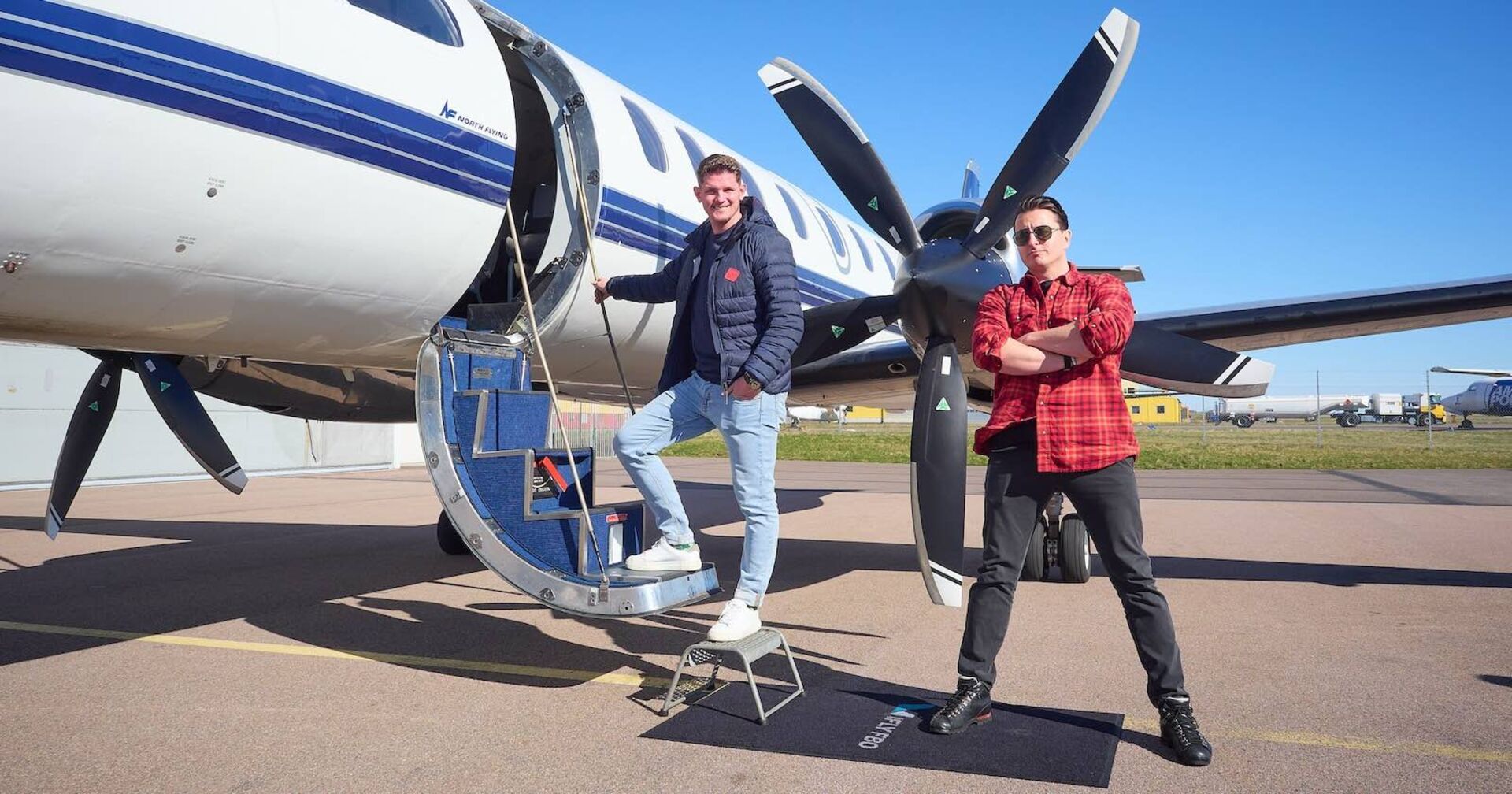 Andreas Gabalier und Thomas Morgenstern vor einen Flugzeug.