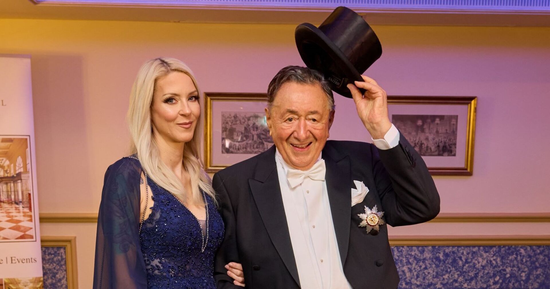 Simone hält Richard Lugner am Oberarm