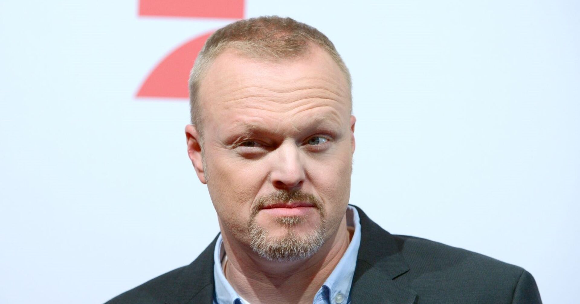Stefan Raab steht vor einer Prosieben-Leinwand.
