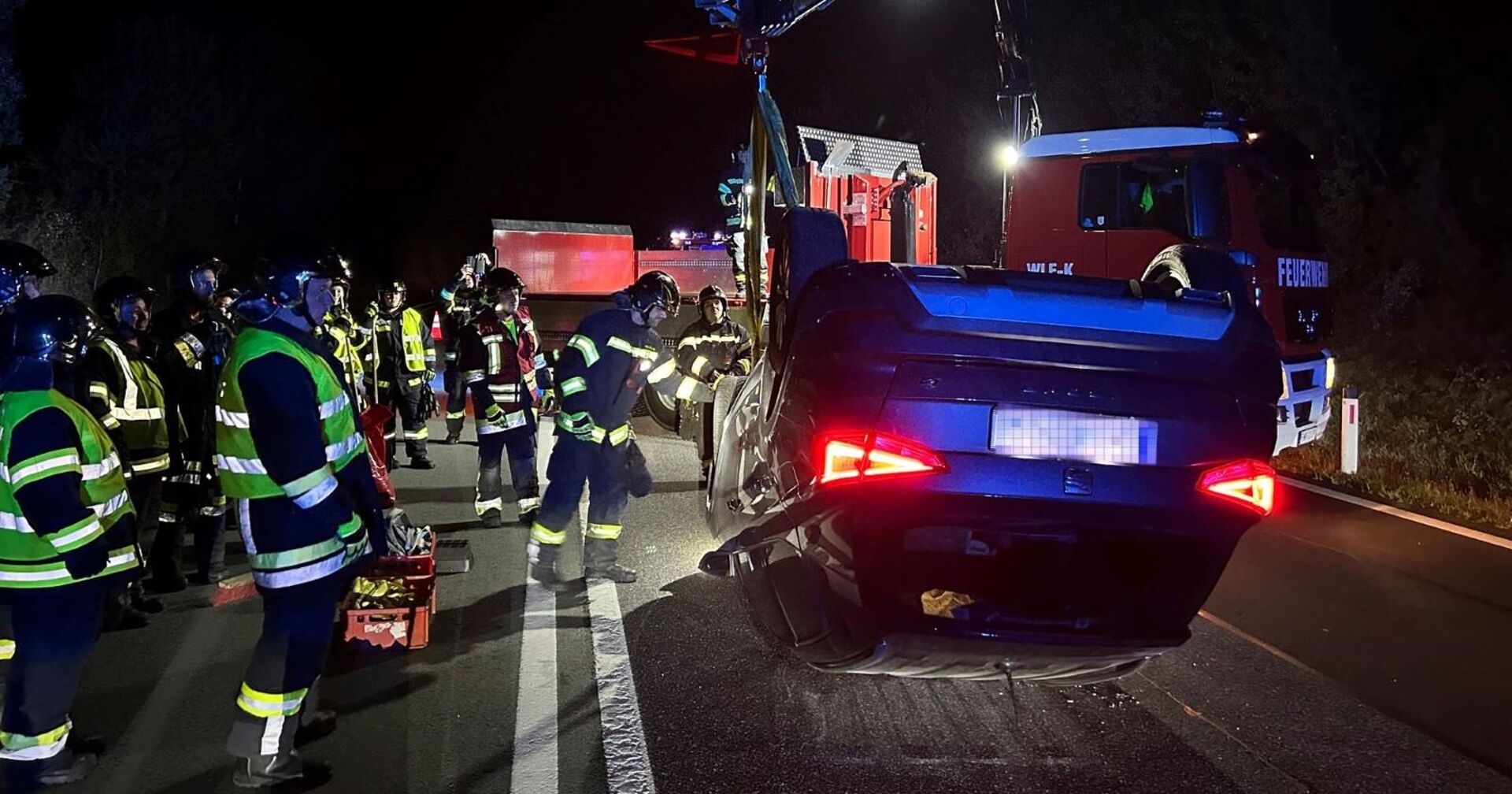 Einsatzkräfte der Feuerwehr vor Ort beim Unfallwagen.