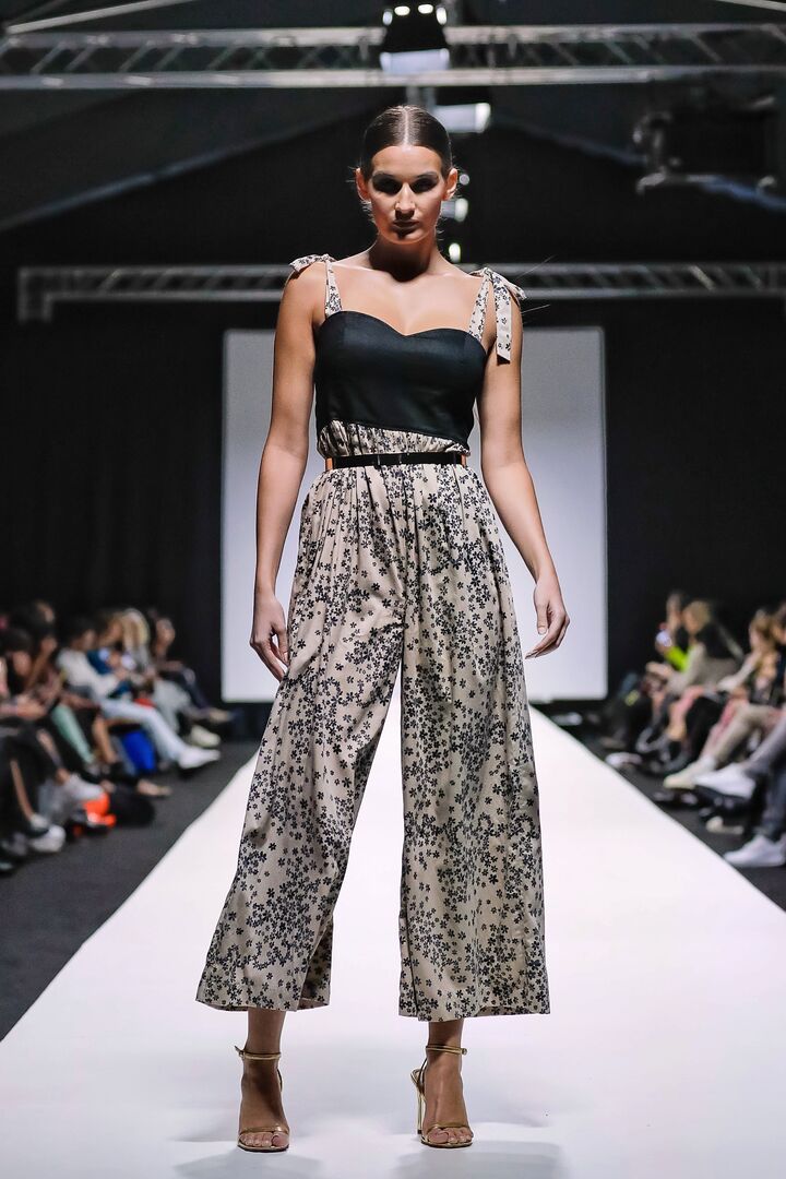 Model in einem Hosenanzug am Laufsteg