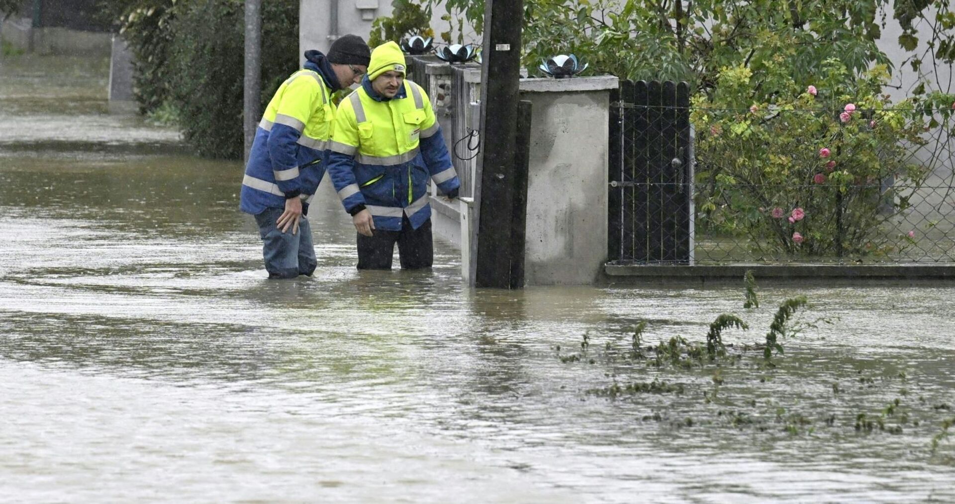 Einsatzkräfte in den Fluten auf der Straße in Pottenbrunn