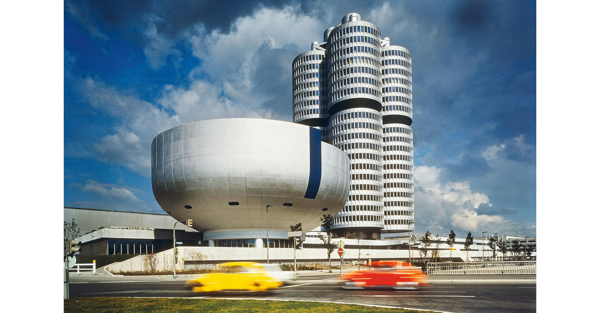 Das BMW Museum im Vordergrund und der BMW Vierzylinder greifen architektonisch die Identität des Fahrzeugherstellers auf.