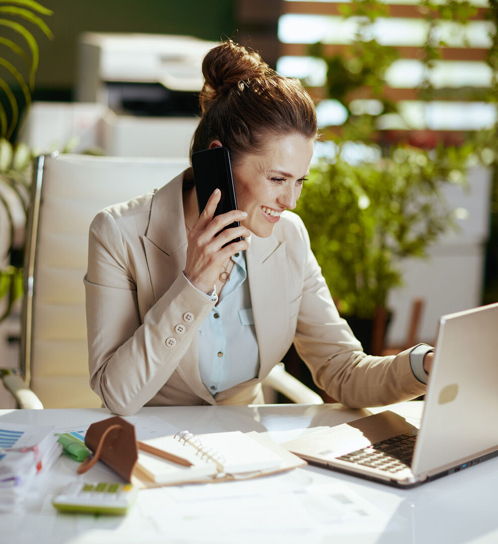 Frau mit rothaarigem Dutt beim Telefonieren im Homeoffice | Credit: iStock.com/CentralITAlliance