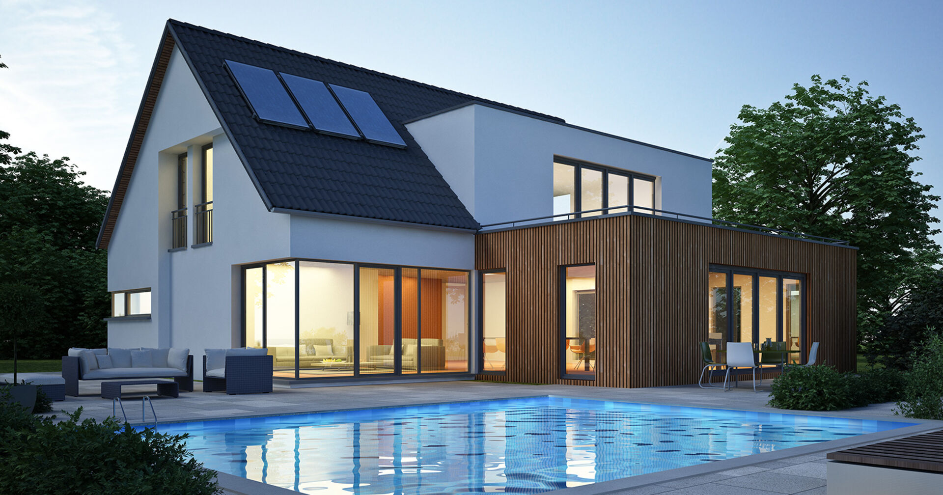 Modernes Wohnhaus mit weißer Fassade und großflächigen Fensterfronten mit Pool in der Abenddämmerung | Credit: iStock.com/Oliver Hasselluhn