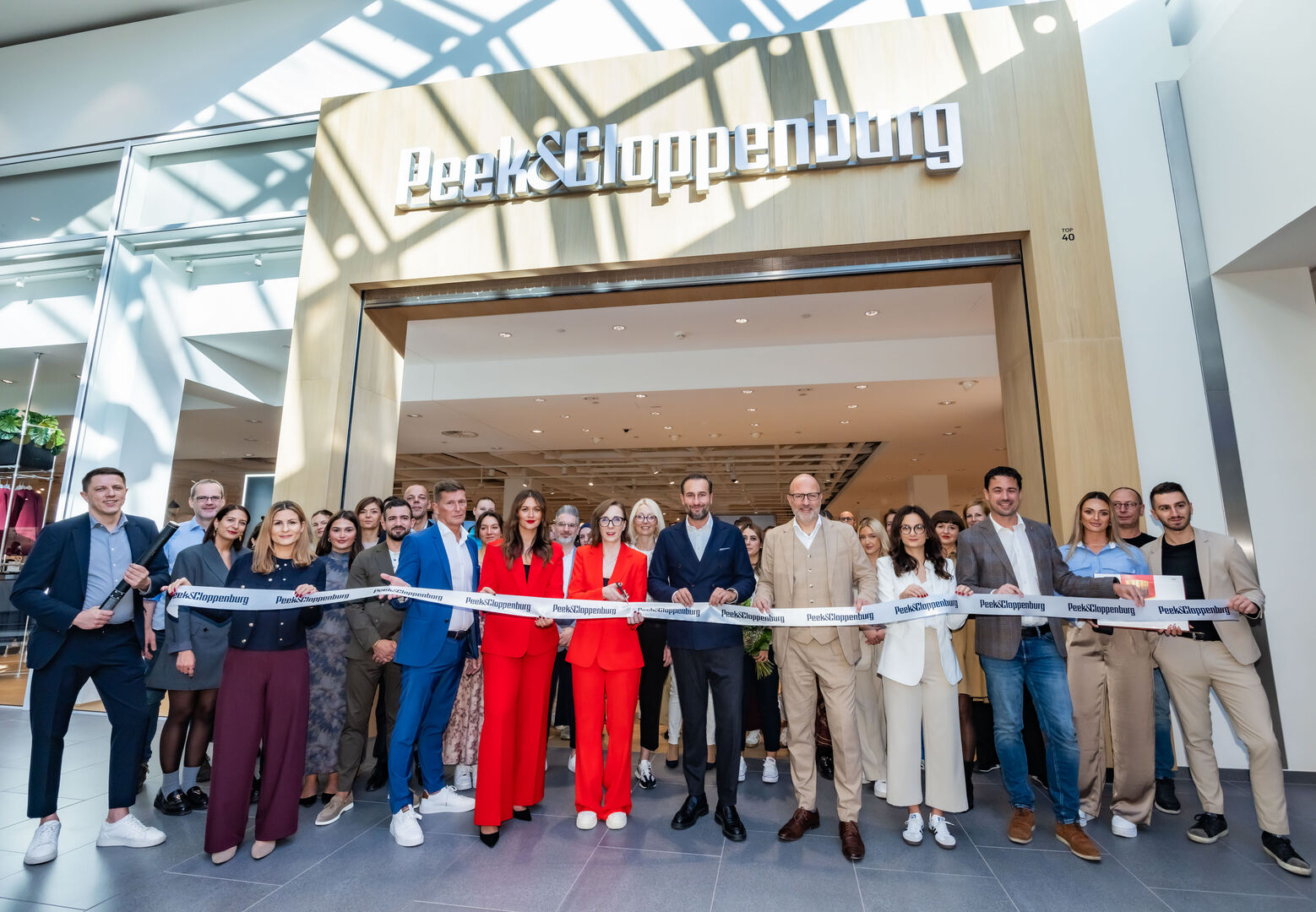 Mehrere Menschen schneiden ein Band durch