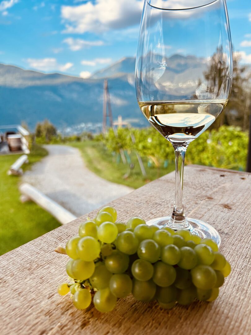 Weinglas und Trauben in der Buschenschank am Weinberg