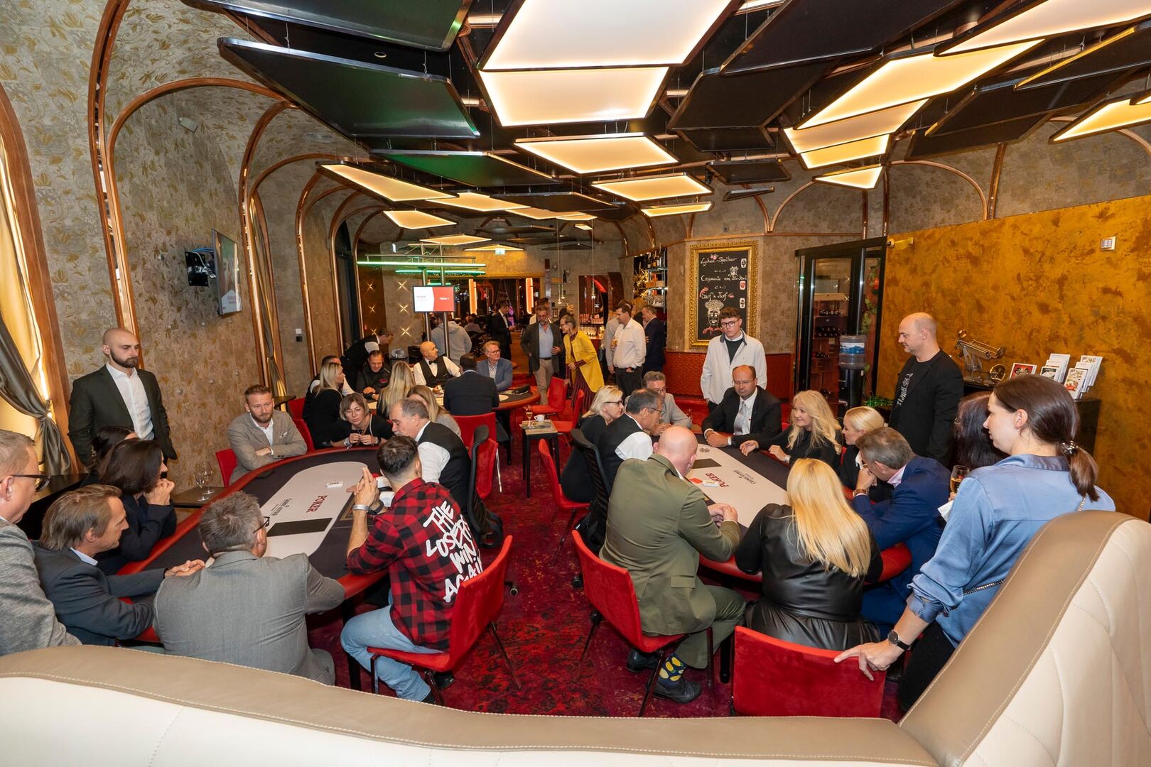 Menschen im Casino an Pokertischen