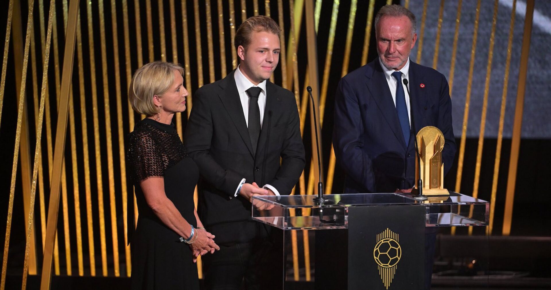 Auf der Bühne: Witwe Heidi Beckenbauer mit Sohn Joel und Ex-Bayern-Boss Karl-Heinz Rummenigge.