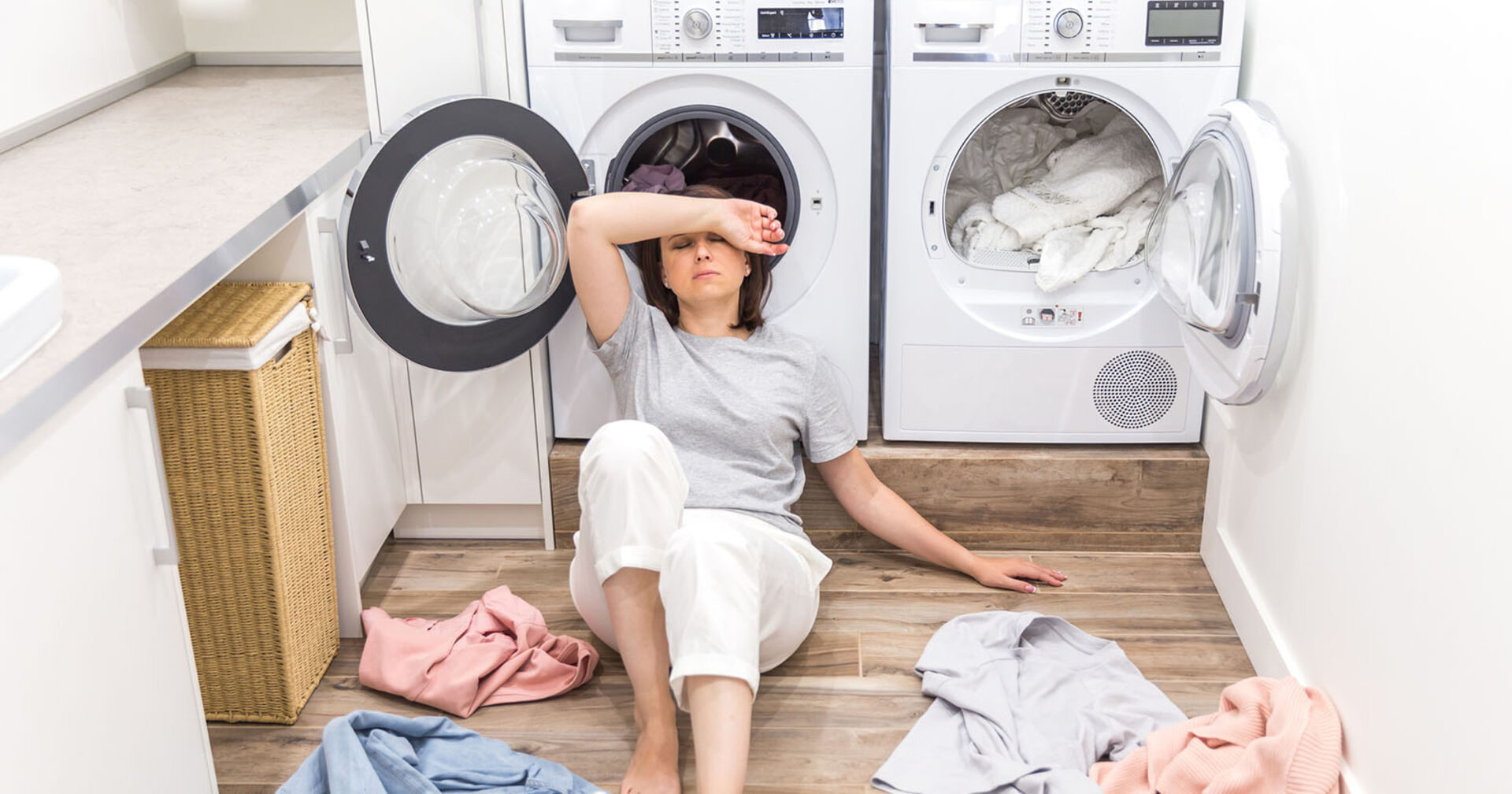Frau sitzt frustriert vor Waschmaschine | Credit: iStock.com/Mariakray