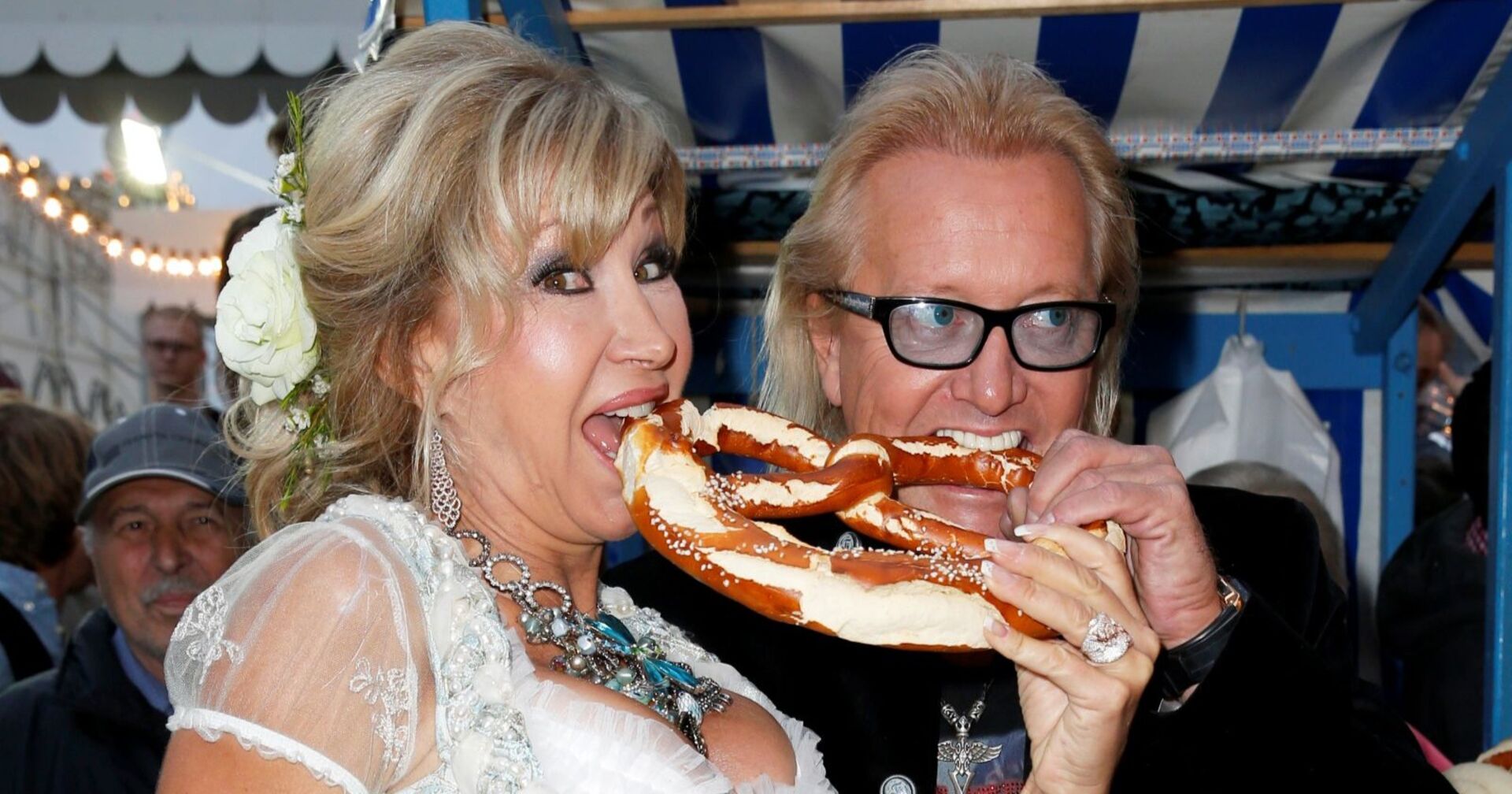 Carmen und Robert Geiss beißen in eine Brezel.