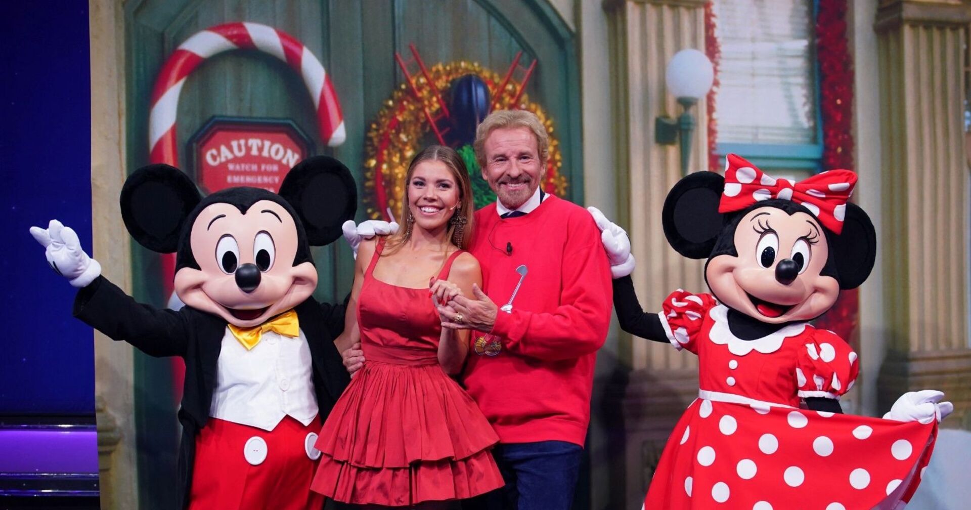 Thomas Gottschalk und Victoria Swarovski posieren mit Mickey und Minnie Mouse.