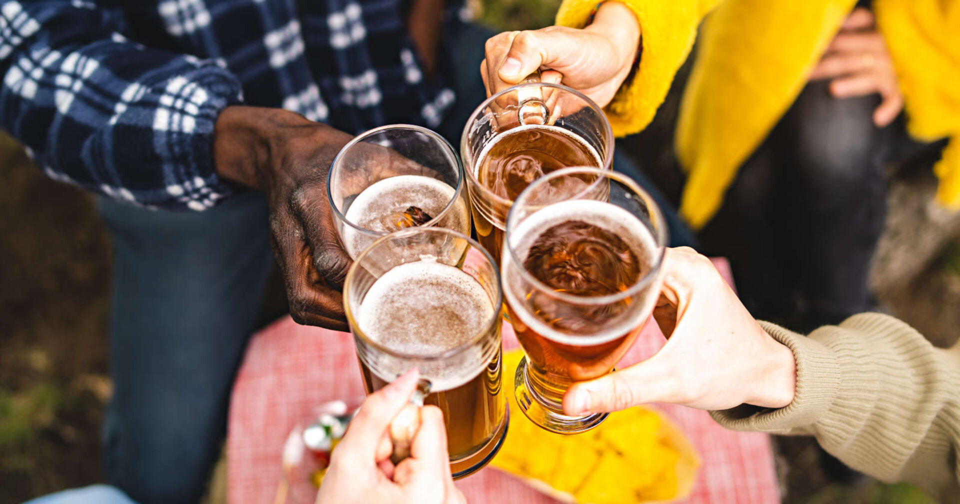 Vier Menschen halten ein Glas in der Hand und stoßen an
