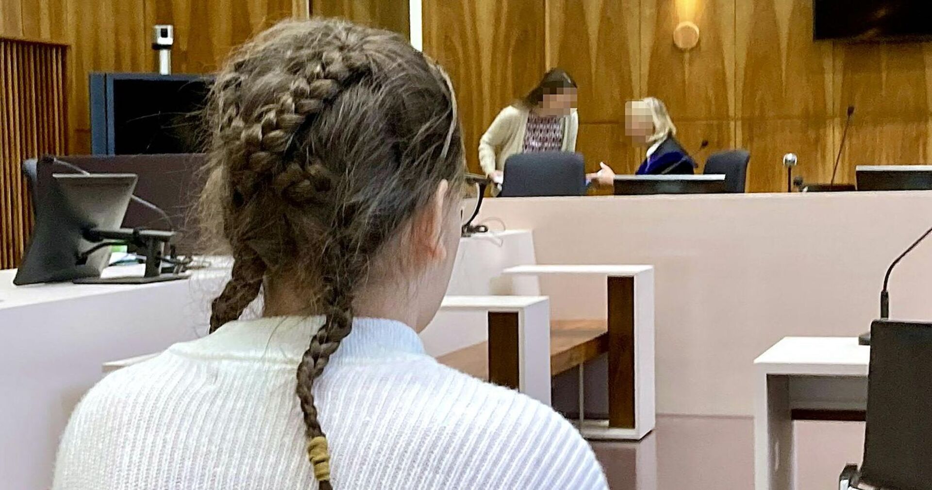 Das 14-jährige Mädchen von hinten vor Gericht.
