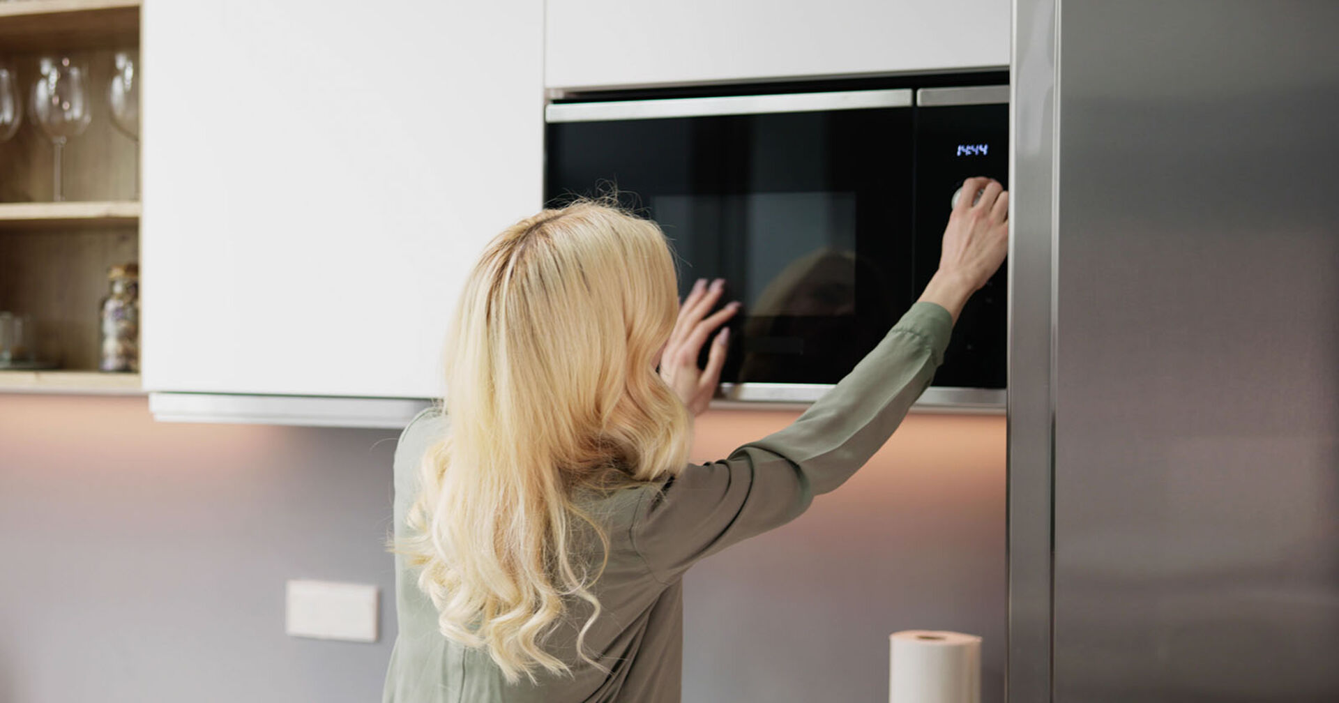 Frau bedient Mikrowelle | Credit: iStock.com/AndreyPopov