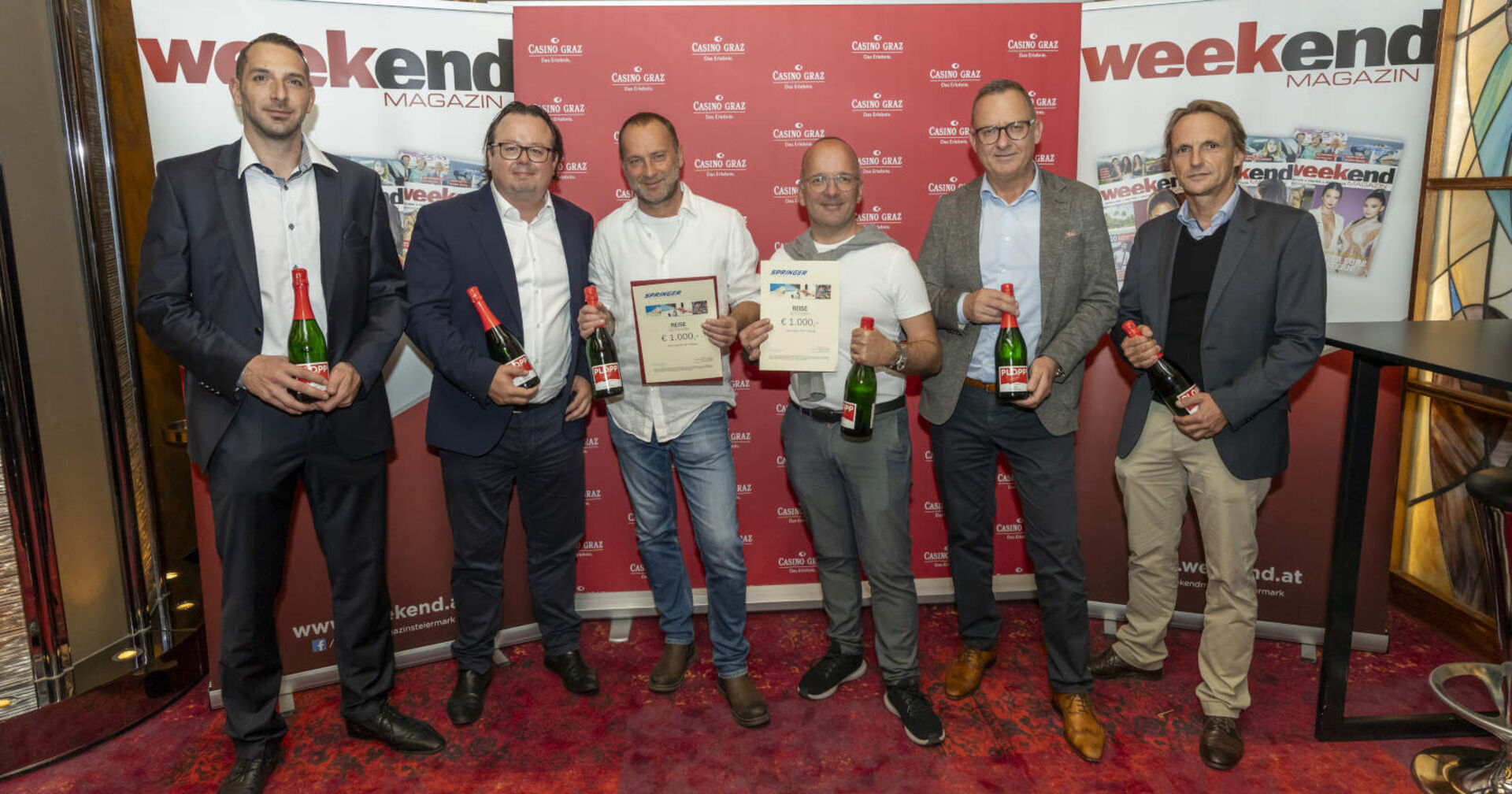 Mehrere Männer lächeln in die Kamera