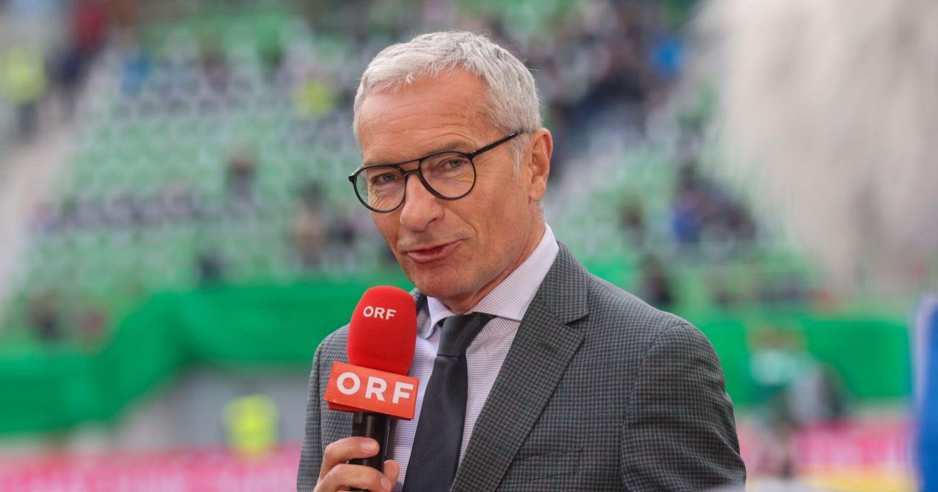 Rainer Pariasek mit ORF-Mikrofon im Stadion