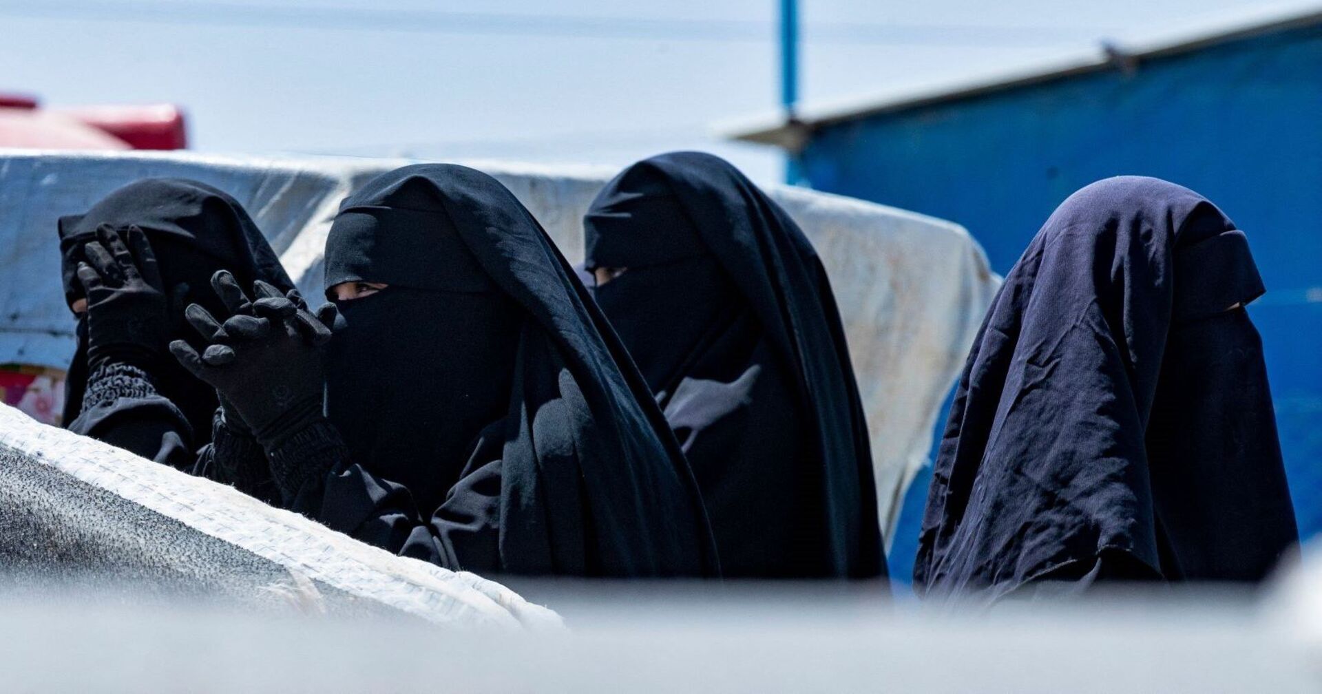 Vier vermummte Frauen in einem syrischen Camp.