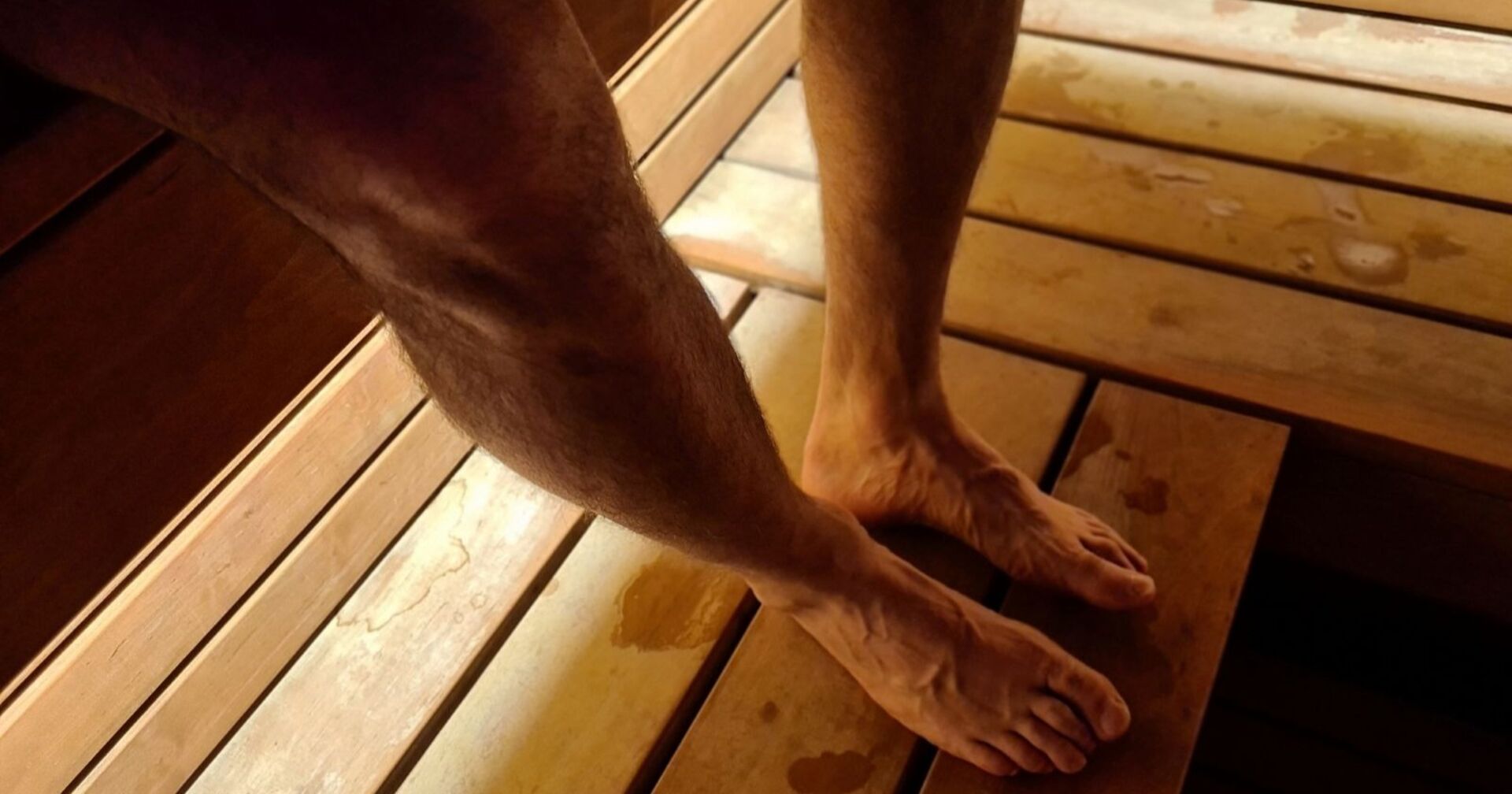 Männerbeine in einer Sauna