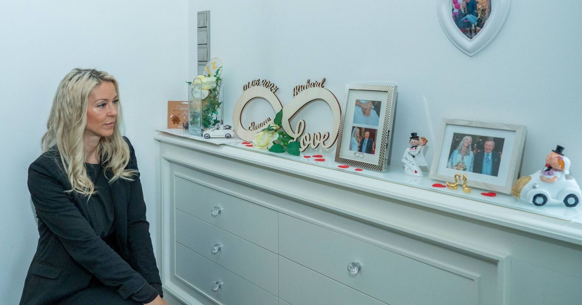 Simone Lugner betrachtet Bilder von Lugner und ihr.