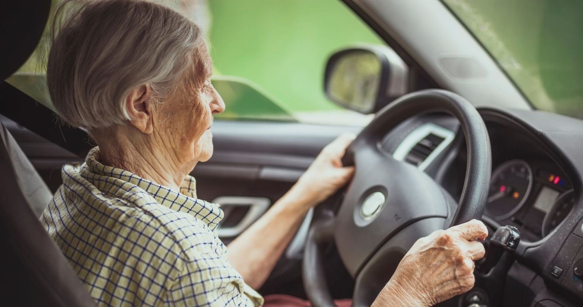 Eine Seniorin hinter dem Steuer eines Pkws.